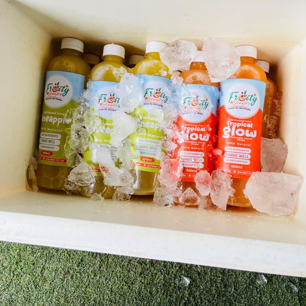 Pineapple and Tropical Glow juice bottles chilled on ice in a cooler box