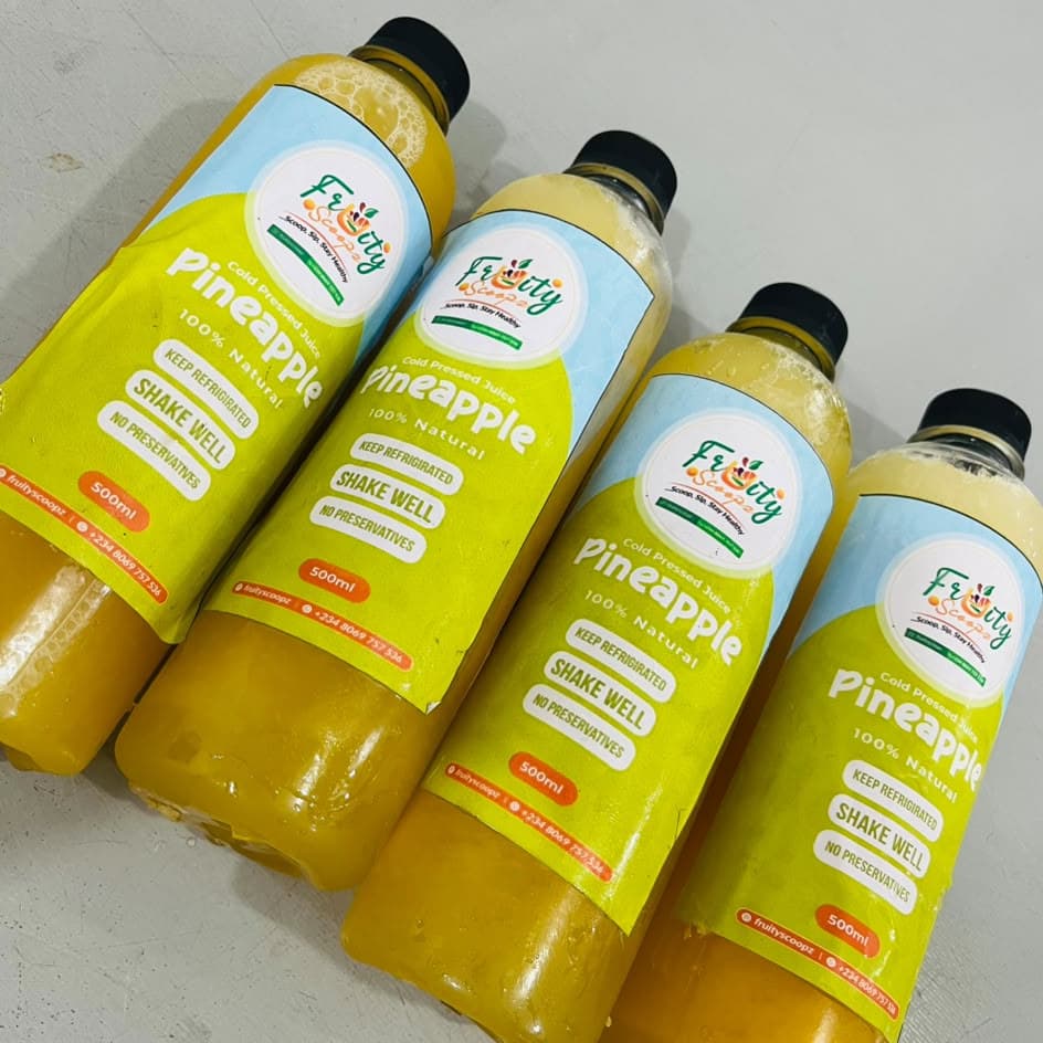 Four bottles of Pineapple juice on a table
